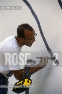 Artist Keith Haring working at the mural Tuttomondo on the rear wall of the Church of SantAntonio in Pisa, 1989 / Lartista Keith Haring mentre lavora al murale Tuttomondo sul muro posteriore della chiesa di SantAntonio abate a Pisa, 1989 - ©Marcello Mencarini/Rosebud2