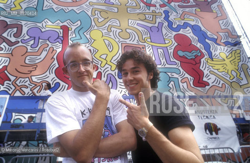 Artist Keith Haring with Piergiorgio Castellani during a break of his mural Tuttomondo on the rear wall of the Church of SantAntonio in Pisa, 1989 / Lartista Keith Haring con Piergiorgio Castellani in una pausa del suo lavoro al murale Tuttomondo realizzato sul muro posteriore della chiesa di SantAntonio abate a Pisa, 1989 - ©Marcello Mencarini/Rosebud2