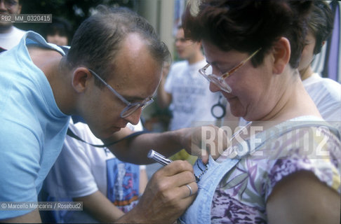 Artist Keith Haring drawss the dress of a woman during his work at the mural Tuttomondo on the rear wall of the Church of SantAntonio in Pisa, 1989 / Lartista Keith Haring disegna il vestito di una signora mentre lavora al murale Tuttomondo sul muro posteriore della chiesa di SantAntonio abate a Pisa, 1989 - ©Marcello Mencarini/Rosebud2