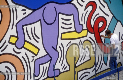 Artist Keith Haring working at the mural Tuttomondo on the rear wall of the Church of SantAntonio in Pisa, 1989 / Lartista Keith Haring mentre lavora al murale Tuttomondo sul muro posteriore della chiesa di SantAntonio abate a Pisa, 1989 - ©Marcello Mencarini/Rosebud2