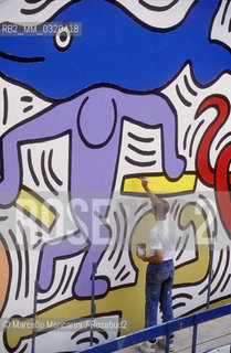 Artist Keith Haring working at the mural Tuttomondo on the rear wall of the Church of SantAntonio in Pisa, 1989 / Lartista Keith Haring mentre lavora al murale Tuttomondo sul muro posteriore della chiesa di SantAntonio abate a Pisa, 1989 - ©Marcello Mencarini/Rosebud2