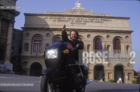 Macerata, 1992, Austrian director Gustav Kuhn on motorbike in front of the Sferisterio / 1992. Il direttore dorchestra Gustav Kuhn in moto davanti allo Sferisterio- ©Marcello Mencarini/Rosebud2