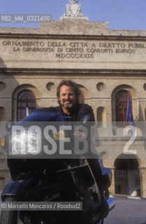 Macerata, 1992, Austrian director Gustav Kuhn on motorbike in front of the Sferisterio / 1992. Il direttore dorchestra Gustav Kuhn in moto davanti allo Sferisterio- ©Marcello Mencarini/Rosebud2