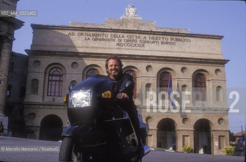 Macerata, 1992, Austrian director Gustav Kuhn on motorbike in front of the Sferisterio / 1992. Il direttore dorchestra Gustav Kuhn in moto davanti allo Sferisterio- ©Marcello Mencarini/Rosebud2