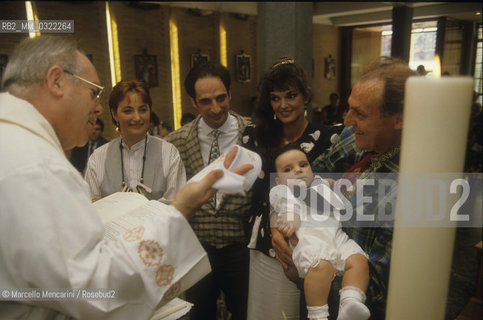 Comic actor Andy Luotto and his wife during the mass for their sons Christening, Italian showman Renzo Arbore as godfather, 1986 / Lattore comico Andy Luotto esua moglie in chiesa durante il battesimo del loro figlio, padrino Renzo Arbore, 1986 - ©Marcello Mencarini/Rosebud2