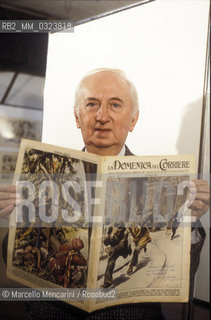 Italian painter and illustrator Walter Molino holding an issue of La Domenica del Corriere magazine, with a cover painted by him(1986) / Il pittore e illustratore Walter Molino mostra una copia della rivista La Domenica del Corriere con una copertina realizzata da lui  (1986) - ©Marcello Mencarini/Rosebud2