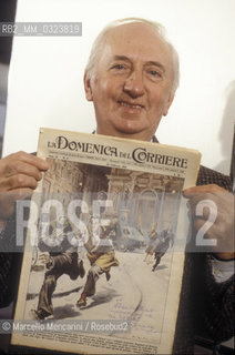 Italian painter and illustrator Walter Molino holding an issue of La Domenica del Corriere magazine, with a cover painted by him(1986) / Il pittore e illustratore Walter Molino mostra una copia della rivista La Domenica del Corriere con una copertina realizzata da lui  (1986) - ©Marcello Mencarini/Rosebud2