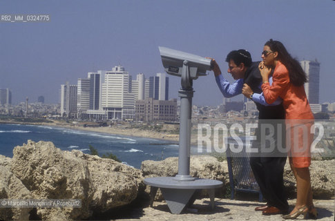 Tel Aviv, 1991. Israeli conductor Daniel Oren and his wife Shulamith Orvieto looking at the panorama through binoculars / Tel Aviv, 1991. Il direttore dorchestra Daniel Oren e sua moglie Shulamith Orvieto mentre guardano il panorama con un binocolo - ©Marcello Mencarini/Rosebud2