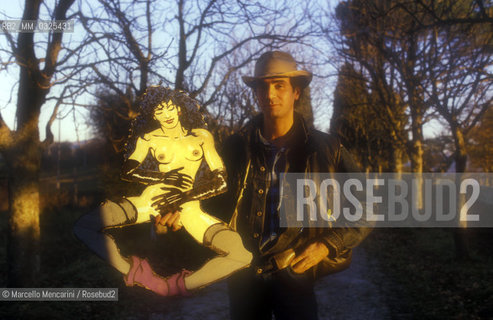 Montepulciano (Siena), 1986. Italian cartoonist Andrea Pazienza in the garden of his house holding a cutout character of his / Montepulciano (Siena), 1986. Il fumettista Andrea Pazienza nel giardino della sua casa con la sagoma di un suo personaggio - ©Marcello Mencarini/Rosebud2