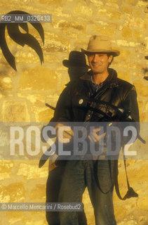 Montepulciano (Siena), 1986. Italian cartoonist Andrea Pazienza in the garden of his house holding a crossbow / Montepulciano (Siena), 1986. Il fumettista Andrea Pazienza nel giardino della sua casa con una balestra - ©Marcello Mencarini/Rosebud2