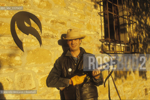 Montepulciano (Siena), 1986. Italian cartoonist Andrea Pazienza in the garden of his house holding a crossbow / Montepulciano (Siena), 1986. Il fumettista Andrea Pazienza nel giardino della sua casa con una balestra - ©Marcello Mencarini/Rosebud2