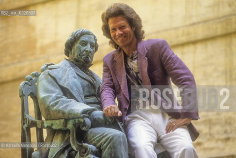 Pesaro, Rossini Opera Festival 1992. American bass-baritone opera singer Samuel Ramey sitting on the Rossinis statue located in the courtyard of the Conservatory / Pesaro, Rossini Opera Festival 1992. Il basso baritono Samuel Ramey seduto sulla statua di Rossini che si trova nel cortile del conservatorio - ©Marcello Mencarini/Rosebud2