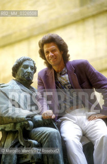 Pesaro, Rossini Opera Festival 1992. American bass-baritone opera singer Samuel Ramey sitting on the Rossinis statue located in the courtyard of the Conservatory / Pesaro, Rossini Opera Festival 1992. Il basso baritono Samuel Ramey seduto sulla statua di Rossini che si trova nel cortile del conservatorio - ©Marcello Mencarini/Rosebud2