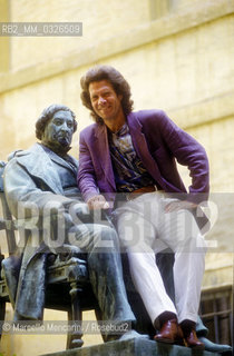 Pesaro, Rossini Opera Festival 1992. American bass-baritone opera singer Samuel Ramey sitting on the Rossinis statue located in the courtyard of the Conservatory / Pesaro, Rossini Opera Festival 1992. Il basso baritono Samuel Ramey seduto sulla statua di Rossini che si trova nel cortile del conservatorio - ©Marcello Mencarini/Rosebud2