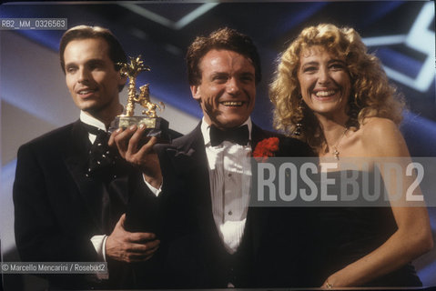 Sanremo Music Festival 1988. Italian pop singer Massimo Ranieri, winner of the Festival with the song Perdere lAmore, with TV presenters Miguel Bosé and Gabriella Carlucci / Festival di Sanremo 1988. Massimo Ranieri, vincitore del Festival con la canzone Perdere lamore, e i presentatori TV Miguel Bosé e Gabriella Carlucci - ©Marcello Mencarini/Rosebud2