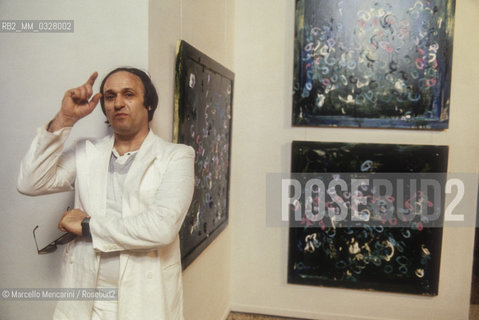 Venice, 1984. Italian artist Mario Schifano in front of some of his paintings / Venezia, 1984. Lartista Mario Schifano di fronte ad alcuni suoi quadri - ©Marcello Mencarini/Rosebud2