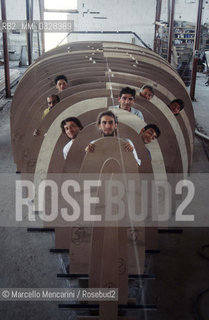 May 1993. Italian sailor Giovanni Soldini (first from the left) in the Toxic Boat shipyards, inside the under contruction hull of his boat to sail solo around the world, built by former drug addicts of the Saman Community with him in the photo / Luglio 1993. Il velista Giovanni Soldini (primo a sinistra) nei cantieri Toxic Boat di Latina, allinterno dello scafo in costruzione della sua barca per il giro del mondo in solitaria realizzato dagli ex tossicodipendenti della Comunità Saman, con lui nella foto - ©Marcello Mencarini/Rosebud2