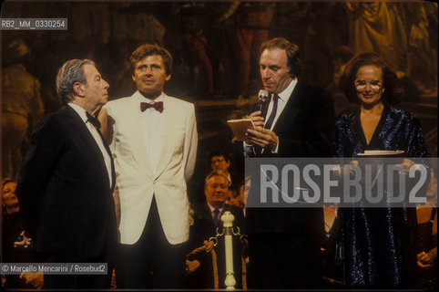 Venice, 1986. From the left: violinist Nathan Milstein receiving the Una Vita per la Musica Award (A Life in Music Award)  by violinist Uto Ughi, journalist-music historian Bruno Tosi and TV announcer Nicoletta Orsomando / Venezia, 1986. Da sinistra: il violinista Nathan Milstein mentre riceve il premio Una vita per la musica dal violinista Uto Ughi, dal giornalista storico della musica Bruno Tosi e dallannunciatrice televisiva Nicoletta Orsomando - ©Marcello Mencarini/Rosebud2