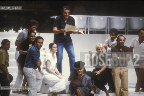 Pesaro, Rossini Opera Festival 1984. Rehearsal of Il viaggio a Reims (The Jorney to Reims) by Gioacchino Rossini. Among the performers: Ruggero Raimondi, holding a sheet, and beyond on the left Katia Ricciarelli, Lucia Valentini Terrani, Leo Nucci. This is the first performance of that opera after the reconstruction of its manuscript, assumed lost, in the 1970s / Pesaro, Rossini Opera Festival 1984. Prova de Il viaggio a Reims di Gioacchino Rossini. Tra gli interpreti: Ruggero Raimondi, con un foglio in mano, and dopo di lui a sinistra Katia Ricciarelli, Lucia Valentini Terrani, Leo Nucci. E la prima rappresentazione dellopera dal ritrovamento e ricomposizione negli anni 70 del suo manoscritto che si credeva perduto - ©Marcello Mencarini/Rosebud2