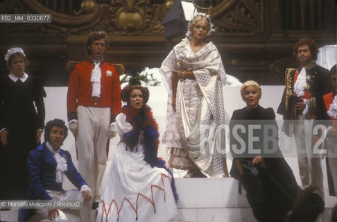 Pesaro, August 18, 1984. Rossini Opera Festival. Staging of Il viaggio a Reims (The Jorney to Reims) by Gioacchino Rossini. Among the others performers: bass-baritone Samuel Ramey as Lord Sidney (third from the left), soprano Lella Cuberli as Contessa di Folleville (fourth from the left), soprano Cecilia Gasdia as Corinna (fifth from the left) and soprano Katia Ricciarelli as Madame Cortese. This is the first performance of that opera, staged by Luca Ronconi and conducted by Claudio Abbado, after the reconstruction of its manuscript, assumed lost, in the 1970s / Pesaro, 18 agosto 1984. Rossini Opera Festival. Messa in scena de Il viaggio a Reims di Gioacchino Rossini. Tra gli altri interpreti: il basso baritono Samuel Ramey nel ruolo di Lord Sidney (terzo da sinistra), il soprano Lella Cuberli nel ruolo di Contessa di Folleville, il soprano Cecilia Gasdia nel ruolo di Corinna e il soprano Katia Ricciarelli nel ruolo di Madame Cortese. E la prima rappresentazione dellopera, con la regia di Luca Ronconi e la direzione dorchestra di Claudio Abbado, dopo il ritrovamento e la ricomposizione negli anni 70 del suo manoscritto che si credeva perduto - ©Marcello Mencarini/Rosebud2