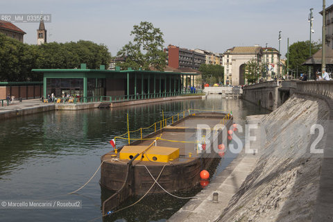 Milan, May 2015. The Milan Darsena after the recent restoration.  This was the old harbour terminal of the Navigli urban canal system,  abandoned and for many years in a state of decay. In the foreground: an old barge used in the past for carrying goods. In the background, on the left: the new indoor market / Milano, maggio 2015. La Darsena dopo i recenti lavori di restauro e riqualificazione urbana. Un tempo era il porto della rete dei Navigli, poi abbandonata e rimasta in rovina per molti anni. In primo piano: una vecchia chiatta destinata un tempo al trasporto fluviale. Sullo sfondo, a sinistra: il nuovo mercato coperto - ©Marcello Mencarini/Rosebud2