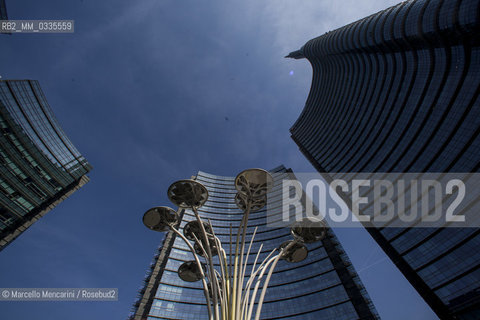 Milan, Piazza Gae Aulenti, Porta Nuova district. The three Pelli Towers designed by architect César Pellii. From the right: the A Tower (Unicredit Tower), the B Tower and the C Tower. In the middle: the sculpure Solar Tree designed by Ross Lovegrove for Artemide / Milano, piazza Gae Aulenti, zona Porta Nuova. Le tre Torri Pelli, progettate dallarchitetto César Pelli. Da destra: la Torre A (Torre Unicredit), la Torre B e la Torre C. Al centro: La scultura  Solar Tree progettata da Ross Lovegrove per Artemide - ©Marcello Mencarini/Rosebud2