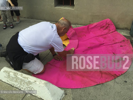 Arles, France, Feria du Riz. Man cleaning a muleta from the blood of the bull outside the Arena where bullfight is / Arles, Francia, Feria du riz. Uomo che pulisce una muleta dal sangue del toro allesterno dellArena dove si svolgono le corride - ©Marcello Mencarini/Rosebud2