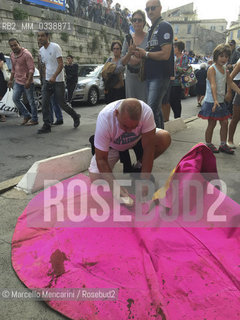 Arles, France, Feria du Riz. Man cleaning a muleta from the blood of the bull outside the Arena where bullfight is / Arles, Francia, Feria du riz. Uomo che pulisce una muleta dal sangue del toro allesterno dellArena dove si svolgono le corride - ©Marcello Mencarini/Rosebud2