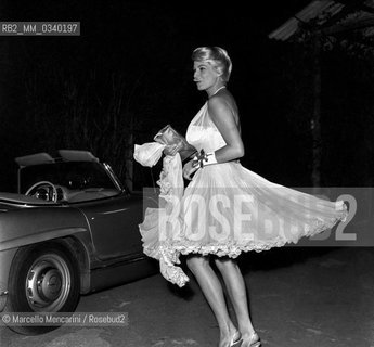 Rome, 1961. Swedish actress Anita Ekberg, wearing an evening dress with pleated skirt, near a car Mercedes Benz 300 SL cabriolet / Roma, 1961. Lattrice svedese Anita Ekberg, in vestito da sera con gonna plissé, vicino a unautomobile Mercedes Benz 300 SL cabriolet - ©Marcello Mencarini/Rosebud2