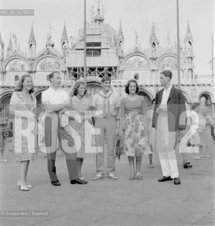 THE PRINCESSES MONIKA AND CRISTIANA LOWENSTEIN, DON JUAN DE BOURBON SICILIAS, PRINCESS JOSEPHINA LOWENSTEIN, THE DUKE CARL VON WURTTENBERG AND THE PRINCE ALOIS LOWENSTEIN IN SAINT MARKS SQUARE IN VENICE- 1958 - © ARCHIVIO Graziano Arici/Rosebud2  / NOBILTA / PRIN