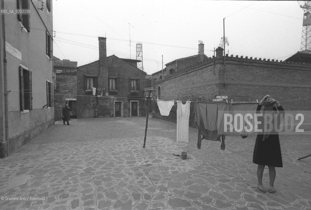 VENEZIA 1977 DONNA CHE STENDE I PANNI ALLA GIUDECCA © ARCHIVIO Graziano Arici/Rosebud2  ISOLA GIUDECCA DONNA CAMPO  CASE