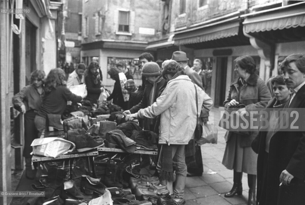 VENEZIA 1979 VENDITA SCARPE DOPO ACQUA ALTA © ARCHIVIO Graziano Arici/Rosebud2  ALTA MAREA CAMPO SAN STIN BAMBINI PROBLEMI DISAGI VENEZIA BANCERELLE  SCARPE
