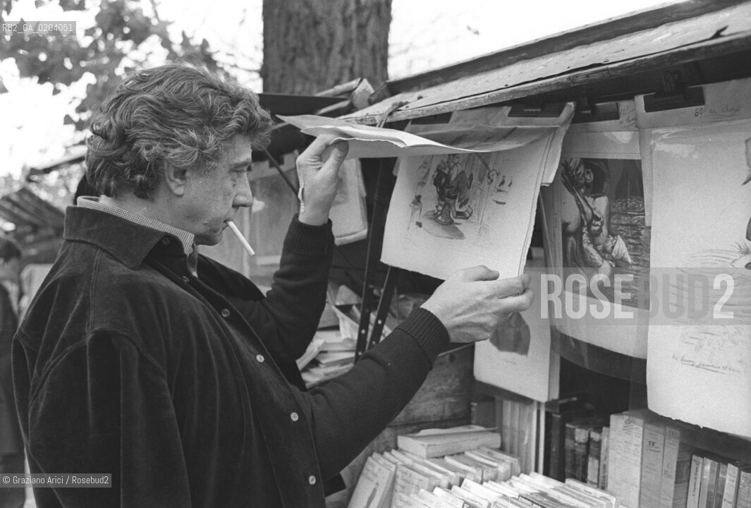 PARIGI 1977 FRANCO BASAGLIA CHE GUARDA UNA BANCARELLA © ARCHIVIO Graziano Arici/Rosebud2  PSICHIATRA FRANCO BASAGLIA OSPEDALE PSICHIATRICO TRIESTE VIAGGIO PARIGI FRANCIA BANCARELLE DISEGNI