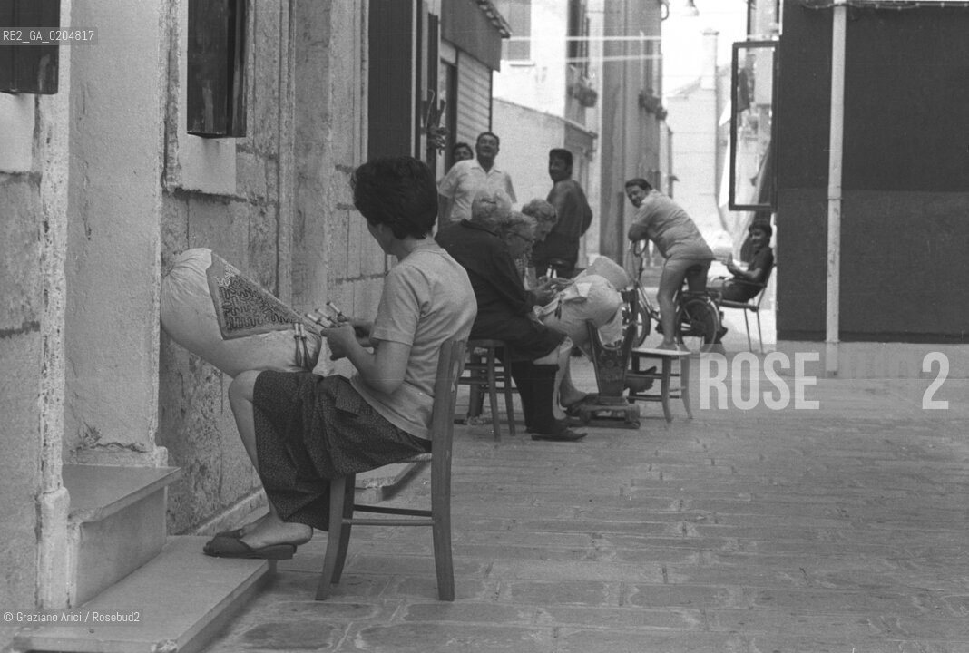 PELLESTRINA 1980 DONNA CHE LAVORA AL TOMBOLO IN STRADA © ARCHIVIO Graziano Arici/Rosebud2  ARTIGIANATO MERLETTI TOMBOLO LAVRO NERO