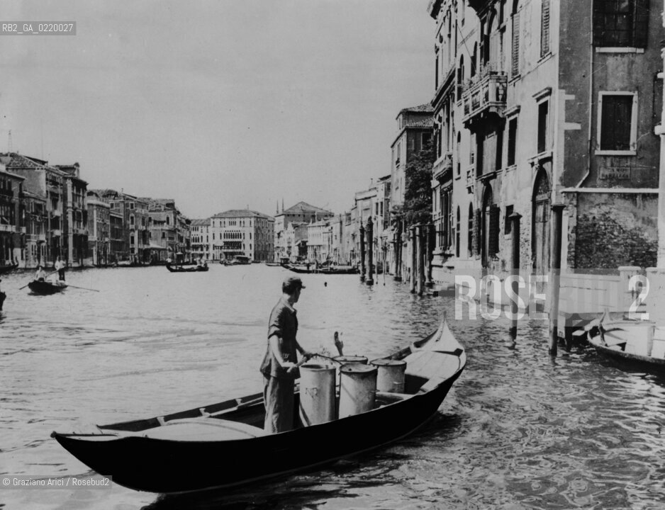 Venice,1952. Spazzino in barca lungo il Canal Grande. This is a part of the morning garbage collection, another task in wich gondolas are used. Gondola, spazzino, Canal Grande - La cessione dei diritti si intende per quanto di nostra competenza; non comprende invece le eventuali spese relative a diritti che potranno essere richiesti dagli Enti cui appartengono le opere riprese. Tali costi, ove neccessari, e l’espletamento di qualsivoglia pratica di richiesta permessi sono esclusivamente  a  carico del committente. © ARCHIVIO Graziano Arici/Rosebud2 