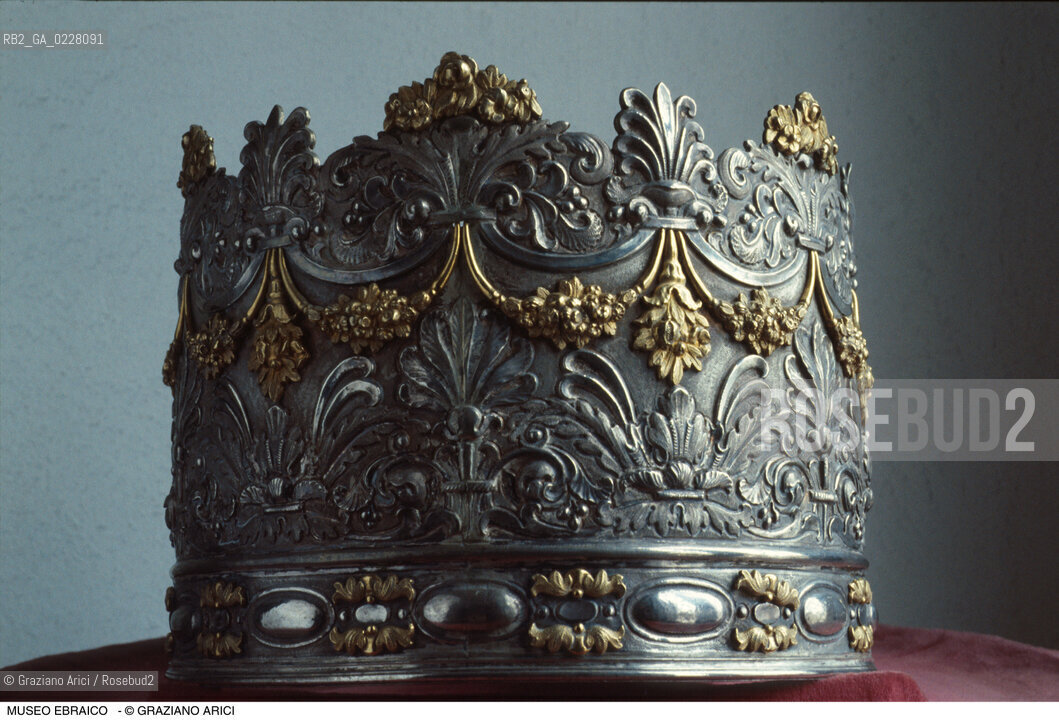 Caption: Nome:..MUSEO DI ARTE EBRAICA : ATARÀ (CORONA) -ADDOBBI DI UN ROTOLO DELLA LEGGE..        ..Localizzazione:..VENEZIA / CANNAREGIO / CAMPO DEL GHETTO NOVO 2902/B / MUSEO DI ARTE EBRAICA  ..VENICE / CANNAREGIO / CAMPO GHETTO NOVO  2902/B / THE MUSEUM OF JEWISH ART     ..Soggetto:..ATARÀ (CORONA) / ADDOBBI DI UN ROTOLO DELLA LEGGE)   ..ATARAH (CROWN) / (DECORATION FOR THE SCROLL OF THE TORAH)   ..Cronologia:..SEC.XIX  ..XIXth CENTURY    ..Autore:......Stile:......Editori Stampatori:......Committenza:......Materia e Tecnica:..ARGENTO E ARGENTO DORATO / ARGENTO  ..SILVER ANDSILVER GILT / SILVER   ....Collocazione:......Note:......Riproduzione Fotografica:  ..Graziano Arici/Rosebud2 ....Copyright:..Graziano Arici/Rosebud2/....Data:..1994 ....Costo:..A....Key:..MUSEI  OGGETTI   ..MUSEUMS  OBJECTS