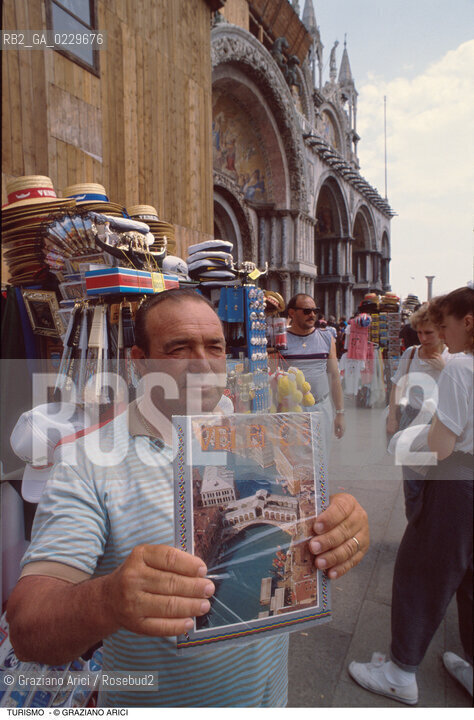 Caption: Localizzazione:..VENEZIA / S. MARCO..Oggetto:..Soggetto:..VENDITORE DI SOUVENIRS IN PIAZZA SAN MARCO..Cronologia: ..Definizione Culturale:..   Autore: ..   Stile: ..   Editori/Stampatori:..   Committenza:..Materia e Tecnica:..Collocazione:..Note:..TURISMO ..Riproduzione Fotografica:..Copyright:..Graziano Arici/Rosebud2 .Data:..1990..Costo:..A
