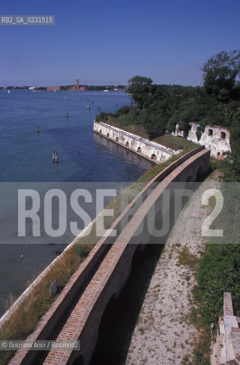 Caption: Nome:..ISOLA DI SANTANDREA: IL FORTE....Localizzazione:..VENEZIA / ISOLA DI SANTANDREA  / LAGUNA NORD..VENICE / THE ISLE OF SANTANDREA / THE NORTH LAGOON..Soggetto:..ISOLA DI SANTANDREA / IL FORTE / MURO DI CINTA / SULLO SFONDO SANT ELENA, VENEZIA..THE ISLE OF SANTANDREA / THE FORT / THE BOUNDARY WALL  / IN THE BACKGROUND SANT ELENA, VENICE..Cronologia:..SEC. XVI SECONDO QUARTO / 1543..XVIth CENTURY / 1543..Autore:..MICHELE SANMICHIELI (1484-1559)....Stile:......Editori Stampatori:......Committenza:..SIGNORIA DI VENEZIA CON DECRETO DEL 23 DICEMBRE 1534..SIGNORIA OF VENICE WITH DECREE OF 23 DECEMBER 1534..Materia e Tecnica:..STRUTTURA IN MATTONI RIVESTITA IN PIETRA DISTRIA..BRICK STRUCTURE COVERED  WITH ISTRIAN STONE..Collocazione:......Note:..LISOLA OSPITA LE CASERME DEL REGGIMENTO LAGUNARI SERENISSIMA / QUI VI FU PREPARATO IL VOLO SU VIENNA DI GABRIELE DANNUNZIO IL 9 AGOSTO DEL 1918..THE ISLAND IS THE SEAT OF THE LAGUNARI SERENISSIMA REGIMENT / HERE, GABRIELE DANNUNZIO ORGANISED THE FLIGHT TO VIENNA ON 9 AUGUST 1918 ..Riproduzione Fotografica:..Graziano Arici/Rosebud2 ...Copyright:..Graziano Arici / rosebud2/....Data:..1998....Costo:..A....Key:..ISOLE ABBANDONATE..UNINHABITED ISLANDS
