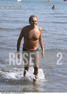 - Venezia,1982.Festival Internazionale dArte Cinematografica di Venezia.Ritratto del presentatore e conduttore televisivo Enzo Tortora Cinema ritratto televisione presentatore - Venice,1982.Venice International Film Festival.Portrait of the tv presenter Enzo Tortora on the beach ©Graziano Arici/Rosebud2