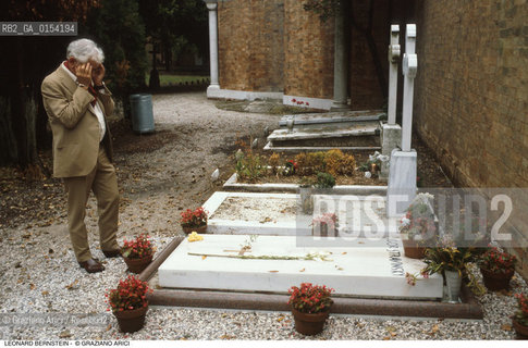-Venezia,1985.San Michele,cimitero.Il direttore dorchestra Leonard Bernstein a Venezia davanti alla tomba del compositore Igor Fëdorovič Stravinskij. Musica classica direttore orchestra ritratto cimitero tomba.-Venice,1985.San Michele.Cemetery.Portrait of the conductor Leonard Bernstein near the tomb of the composer Igor Fëdorovič Stravinskij ©Graziano Arici/Rosebud2