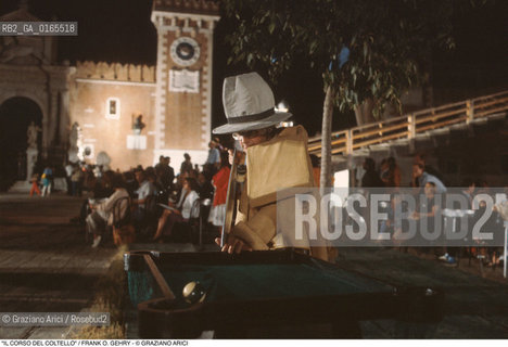 Nome: .IL CORSO DEL COLTELLO DI CLAES OLDENBURG E COOSJE VAN BRUGGEN .Descrizione: .ARTE PERFORMANCE / LARCHITETTO FRANK O. GEHRY CON COSTUME DI GOMMAPIUMA E GRANDE CAPPELLO GIOCA A BILIARDO / ALLARSENALE .Credit: ©Graziano Arici/Rosebud2 Costo: ..Nazione: .ITALIA.Cittˆ: .VENEZIA.Data: .1984.