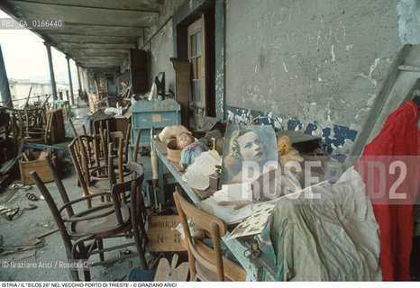 Nome: .REGIONE ISTRIA.Descrizione: .IL SILOS 26 CHE CONTIENE OGGETTI E MASSERIZIE DEI PROFUGHI ESULI ISTRIANI DEL DOPOGUERRA / SOTTO LA TUTELA DELLI.R.C.I. NEL VECCHIO PORTO / SEDIE BAMBOLA ORSACHIOTTO FOTO BANDIERA.Credit: ©Graziano Arici/Rosebud2 / Costo: .A.Nazione: ..Cittˆ: .TRIESTE.Data: .1995