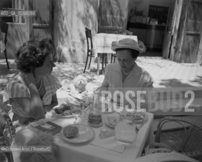 THE ART COLLECTOR PEGGY GUGGENHEIM WITH THE PRINCESS ASPASIA OF GREECE HAVING DINNER AT THE INTERNATIONAL ART EXPOSITION - VENICE - 1948 © ARCHIVIO Graziano Arici/Rosebud2  / ARTE / COLLEZIONISTA / NOBILI / BIENNALE