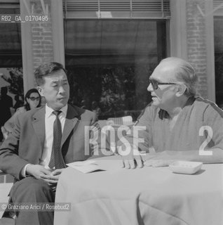 DELEGATO CINESE CON IL PRODUTTORE MARK SPIEGEL (USA) CON OCCHIALI NERI / SEDUTI A UN TAVOLINO / 1971 - © ARCHIVIO Graziano Arici/Rosebud2 .