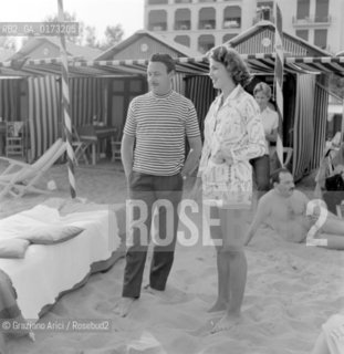 THE PRINCESS IRA FURSTENBERG WITH HER HUSBAND THE PRINCE ALFONSO HOHENLOHE AT THE INTERNATIONAL FILM FESTIVAL IN VENICE LIDO - 1957 © ARCHIVIO Graziano Arici/Rosebud2  / NOBILE / MATRIMONIO / PRINCIPI / MOSTRA DEL CINEMA / SPIAGGIA