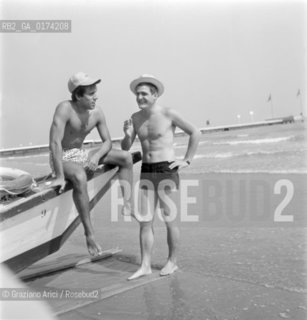 THE POP SINGER ADRIANO CELENTANO WITH THE POP SINGER NINO SANTERCOLE AT VENICE LIDO BEACH  - 1964 © ARCHIVIO Graziano Arici/Rosebud2  /  MUSICA POP / CANTANTE POP / SPIAGGIA