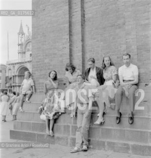 THE PRINCESSES MONIKA AND CRISTIANA LOWENSTEIN, DON JUAN DE BOURBON SICILIAS, PRINCESS JOSEPHINA LOWENSTEIN, THE DUKE CARL VON WURTTENBERG AND THE PRINCE ALOIS LOWENSTEIN IN SAINT MARKS SQUARE IN VENICE- 1958 - © ARCHIVIO Graziano Arici/Rosebud2  / NOBILTA / PRIN
