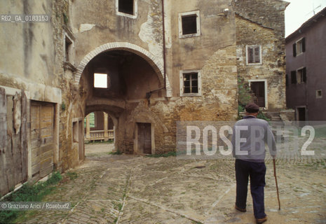 ( CROAZIA  ) ISTRIA - PORTOLE :LULTIMO ABITANTE ITALIANO DAVANTI ALLE CASE ABBANDONATE E DIROCCATE  - © 2001 Graziano Arici/Rosebud2 / GEO / LINGUA / MINORANZA