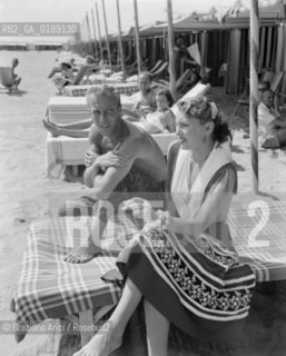 THE FASHION STYLIST JACQUES FATH WITH HIS WIFE AT VENICE LIDO BEACH - 1950 © ARCHIVIO Graziano Arici/Rosebud2  / MODA / STILISTA / SPIAGGIA