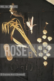 ( FRANCIA  )  LANGUEDOC-ROUSSILLON ALTIPIANO DEL LARZAC CAUSSE : PORTA CON OGGETTI PORTAFORTUNA© 1999 Graziano Arici/Rosebud2 / GEO CONCHIGLIA FERRO DI CAVALLO PIUME SPAZZOLA